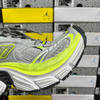 Grey and neon yellow running sneaker, angled side view with chunky tread sole