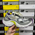 Front three-quarter view of gray sneakers with purple details and neon lime laces