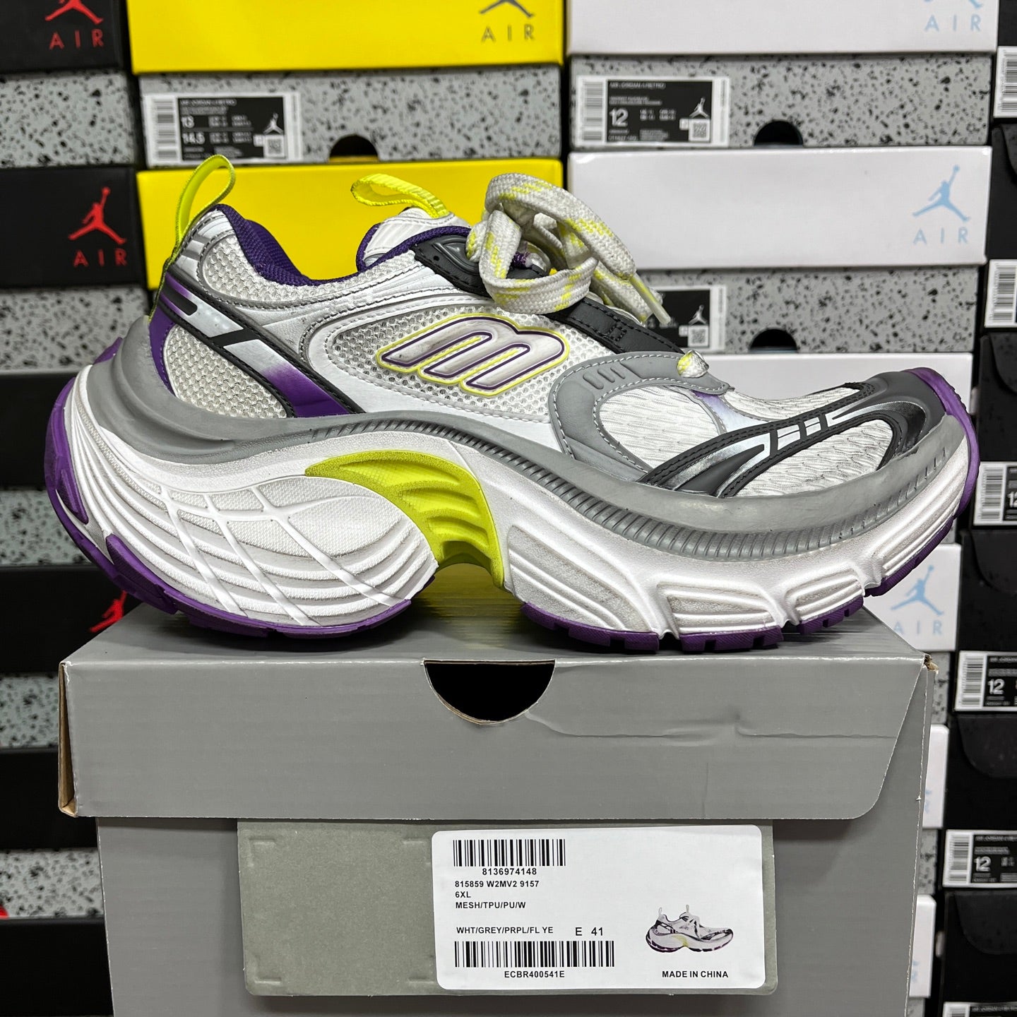 Gray and white lace-up sneakers with purple side panel and neon green outsole