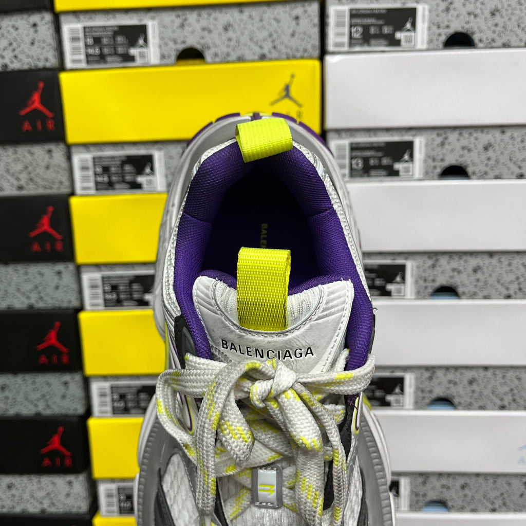 Heel view of gray sneakers with purple lining and neon lime pull-tab