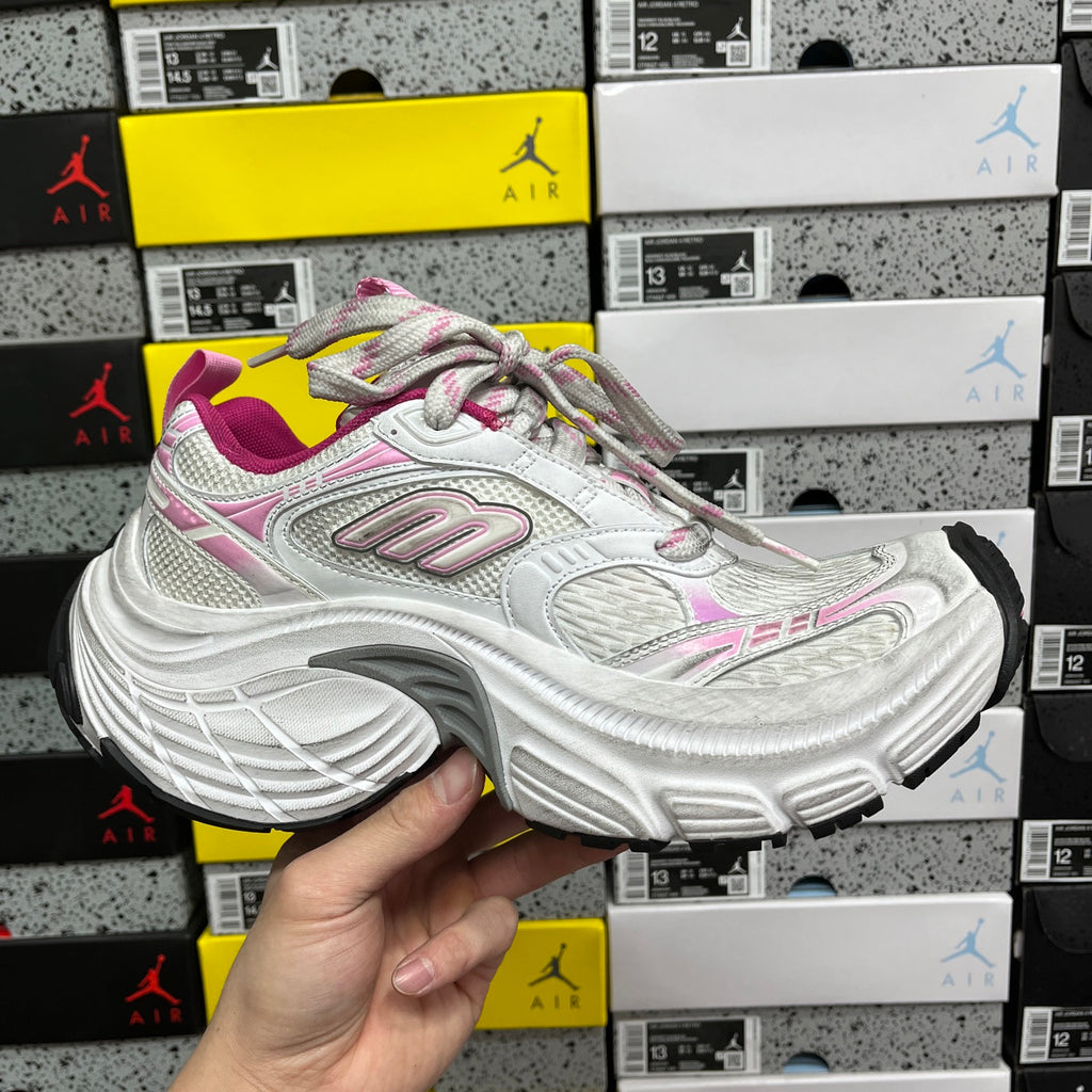 White sneaker with pink and gray accents, multicolor laces, and thick sole
