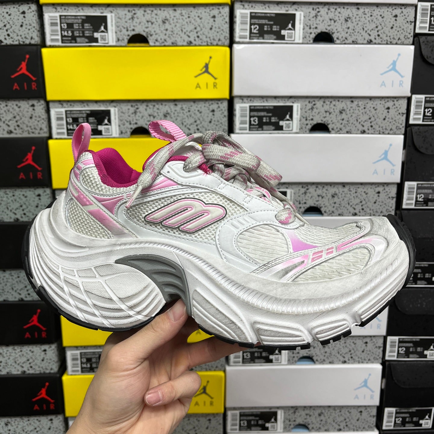 White lace-up sneaker with pink accents and chunky gray-and-white sole
