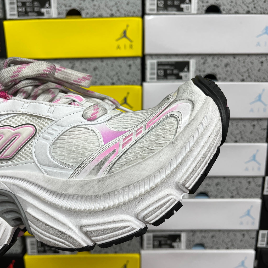 White sneaker side profile with chunky sole and black traction pads at heel