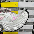 White sneaker side profile with chunky sole and black traction pads at heel