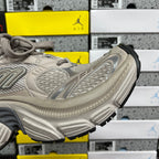 Light gray sneakers with sculpted heel, ribbed side panels and chunky rubber sole