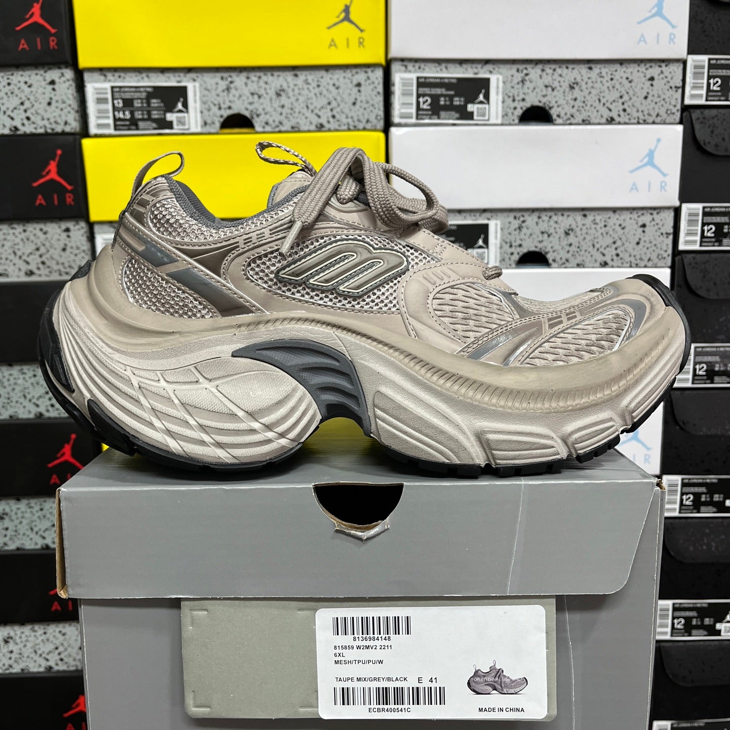 Light gray lace-up sneakers with textured overlays and thick, blue-tinted sole