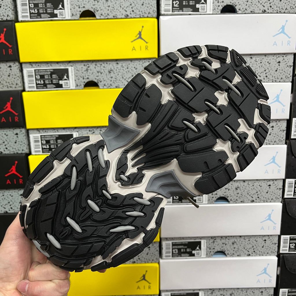 Chunky sneaker outsole with black-and-gray tread, showing circular traction blocks