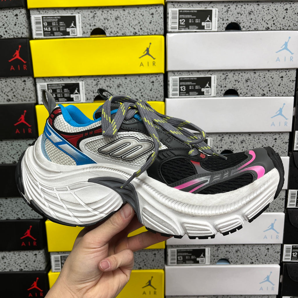 Balenciaga sneakers angled view, black and gray upper, blue panel, white sole, multicolor laces