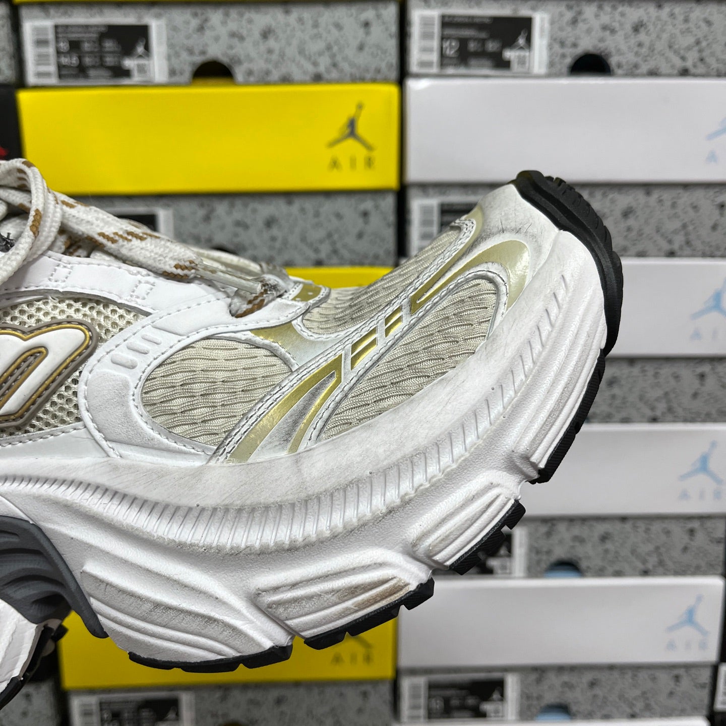 White Balenciaga sneakers with gold stripe detailing and molded tread sole, lace-up.