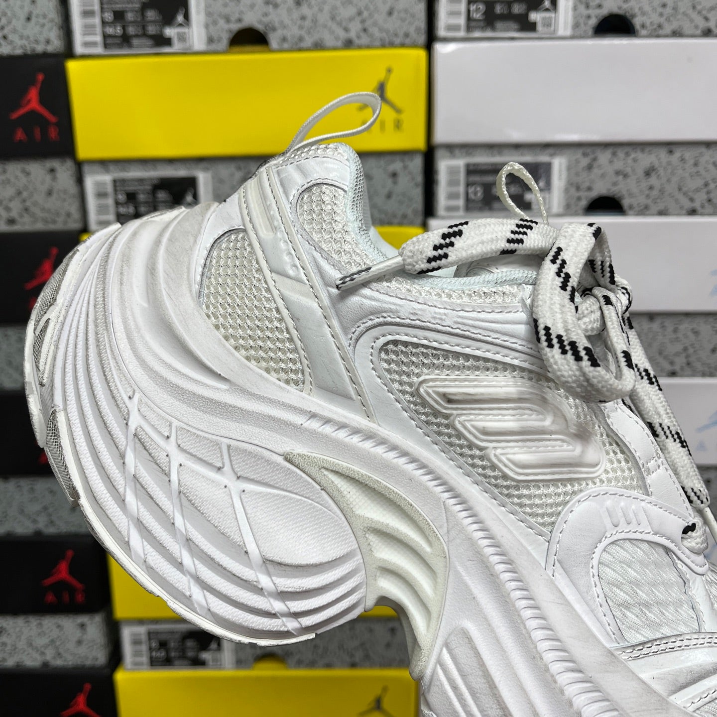 White Balenciaga sneaker side view with mesh panel, laces, and chunky tread sole