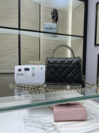 Black quilted Chanel shoulder bag with long chain strap and flap front, gold clasp