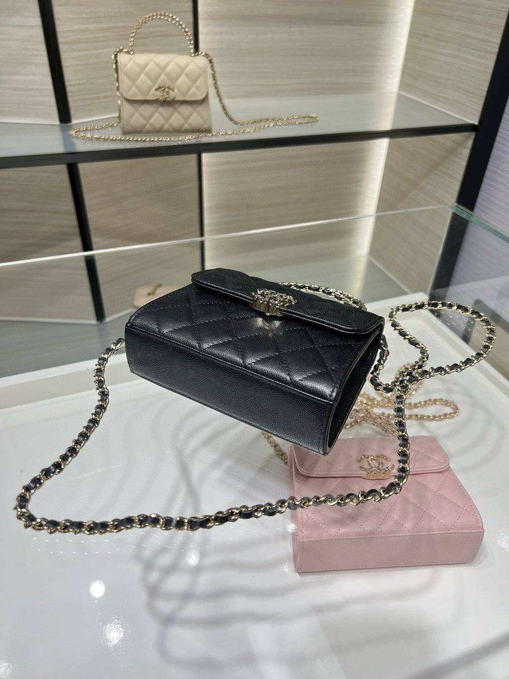 Black Chanel quilted crossbody bag with chain strap and gold-tone buckle clasp