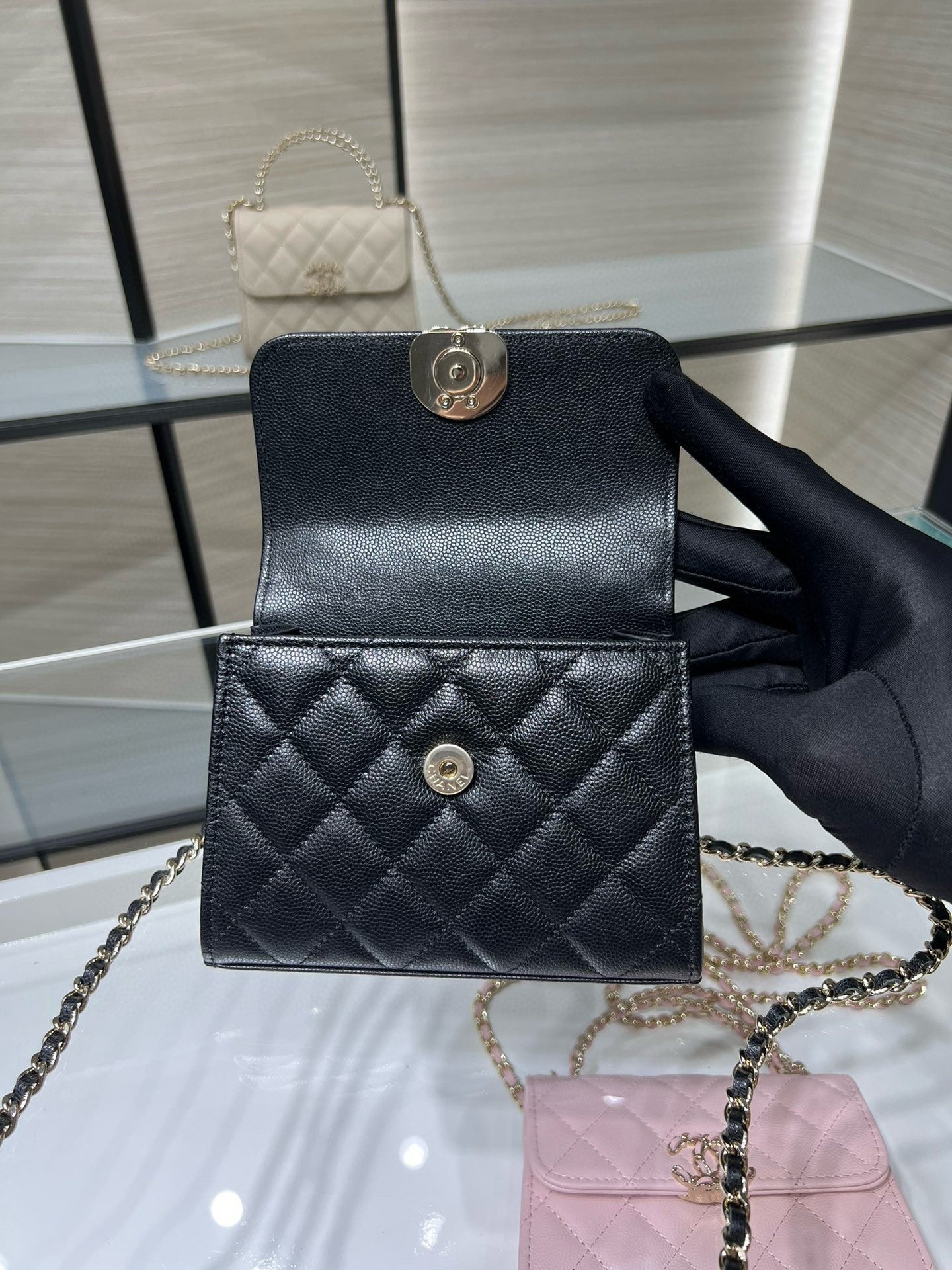 Black Chanel quilted mini bag with chain strap and round turn-lock closure