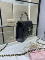 Black quilted Chanel top-handle bag with front flap and chain shoulder strap