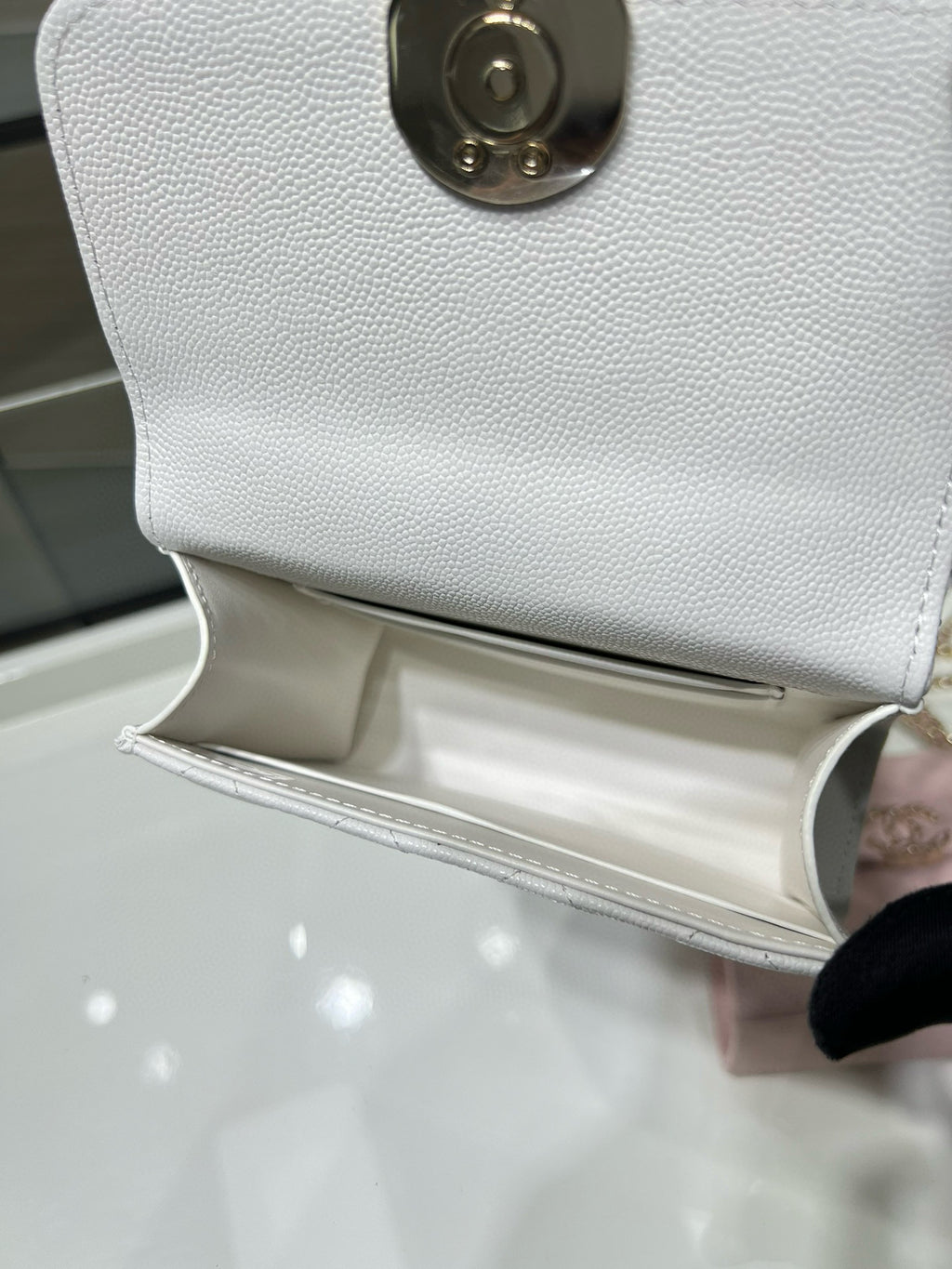 Chanel white leather bag with open flap and gold hardware on textured exterior