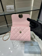 Pink quilted mini crossbody bag with front flap and circular clasp