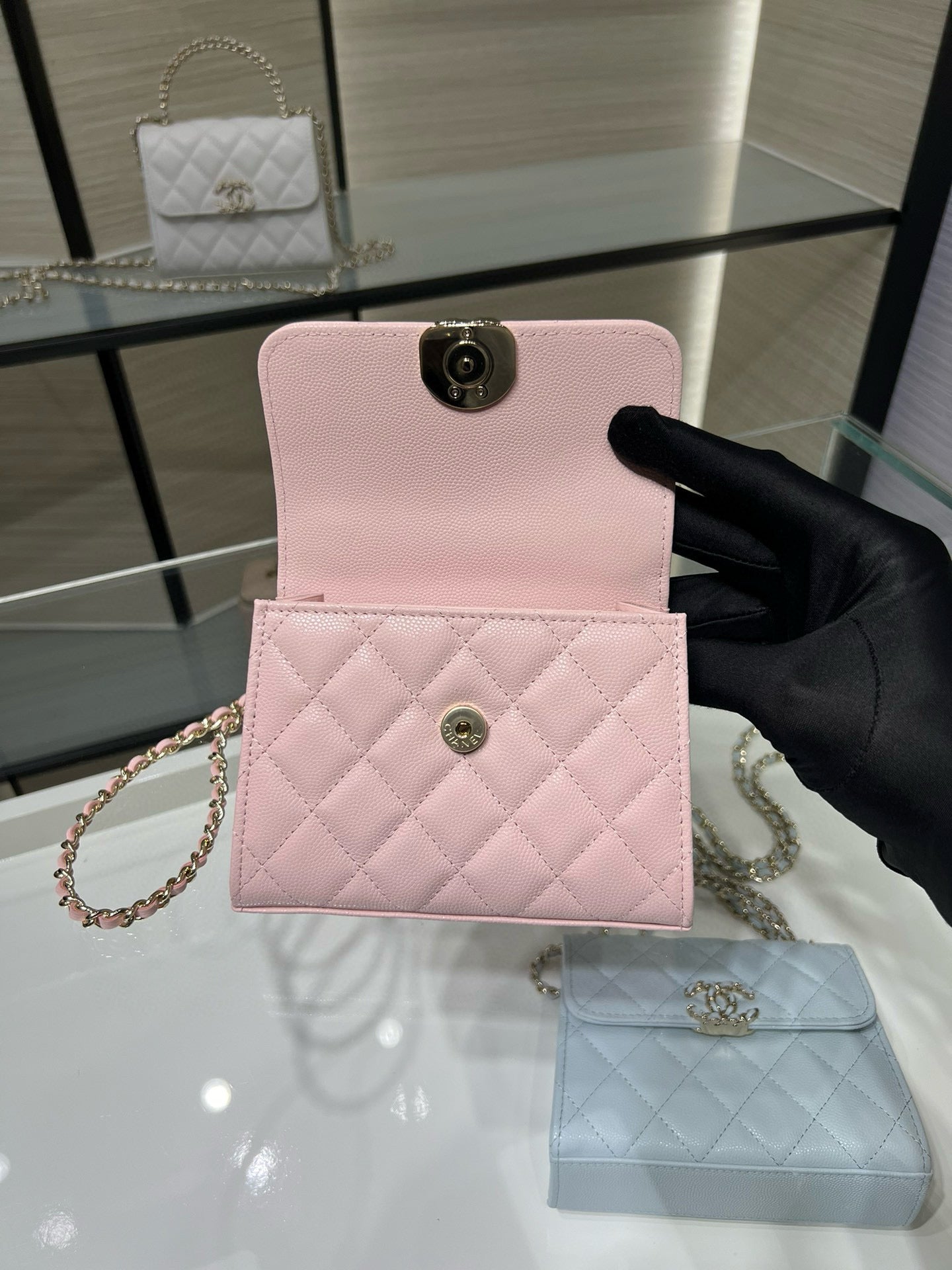 Pink quilted mini crossbody bag with front flap and circular clasp