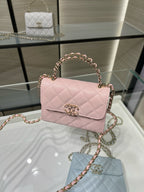 Pink quilted crossbody handbag with short top handle, gold clasp, and chain