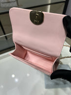 Pink quilted mini handbag with gold-tone top clasp and chain strap
