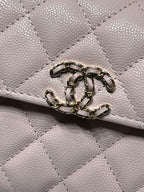 Close-up of quilted pink leather handbag flap hardware and ring clasp