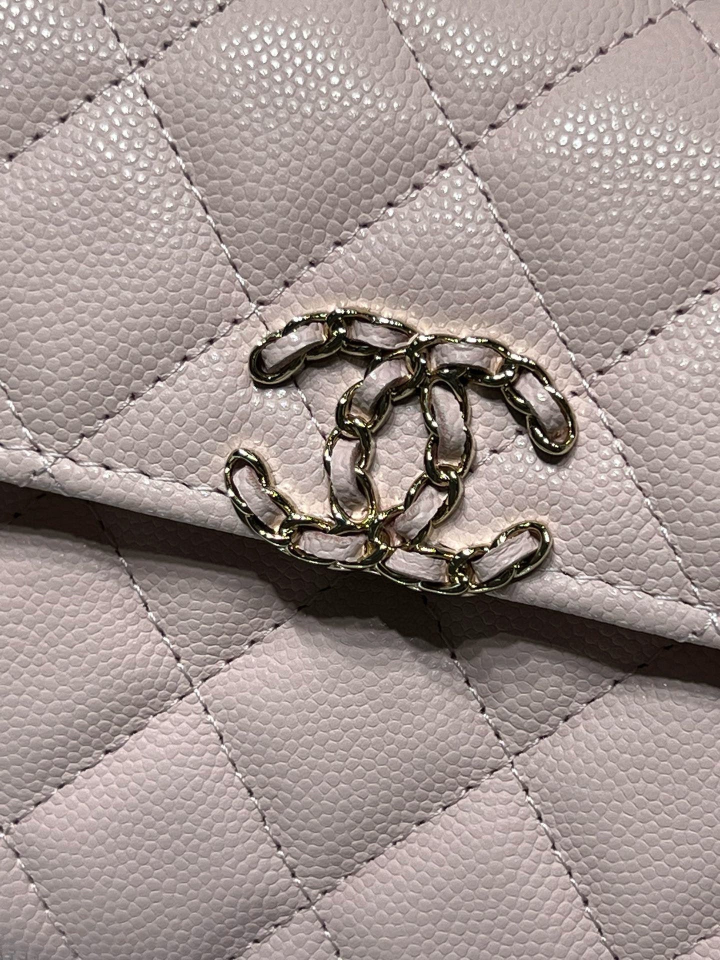 Close-up of quilted pink leather handbag flap hardware and ring clasp