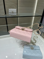 Pink quilted top-handle bag with gold-tone clasp and chain strap