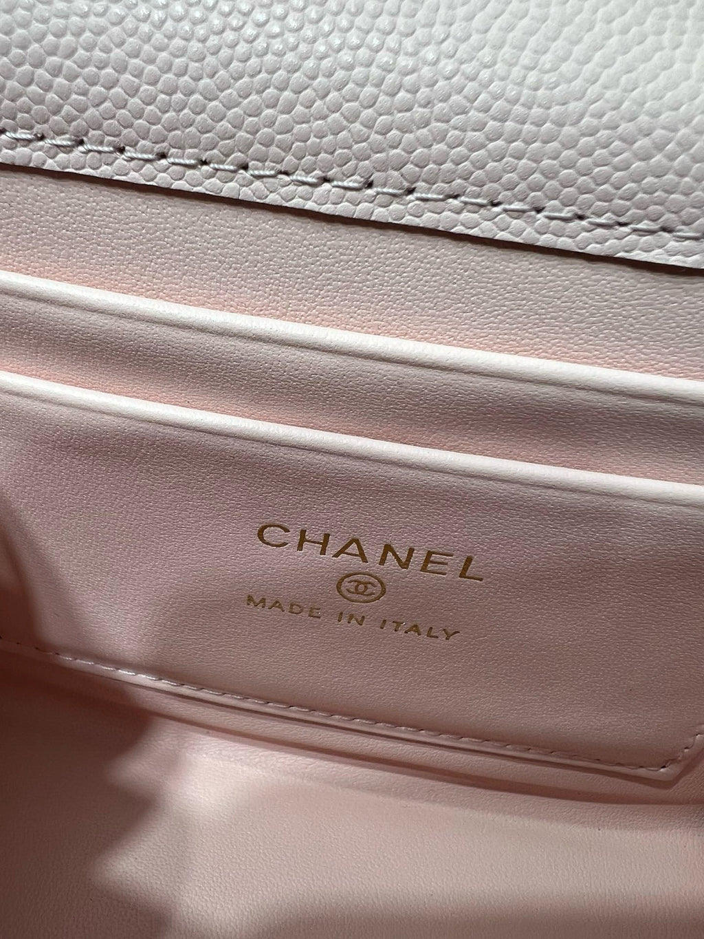 Pink leather handbag interior label reading CHANEL made in Italy