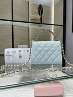 Light blue quilted handbag with flap closure and gold-tone chain shoulder strap