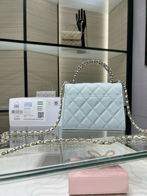 Light blue quilted handbag with flap closure and gold-tone chain shoulder strap