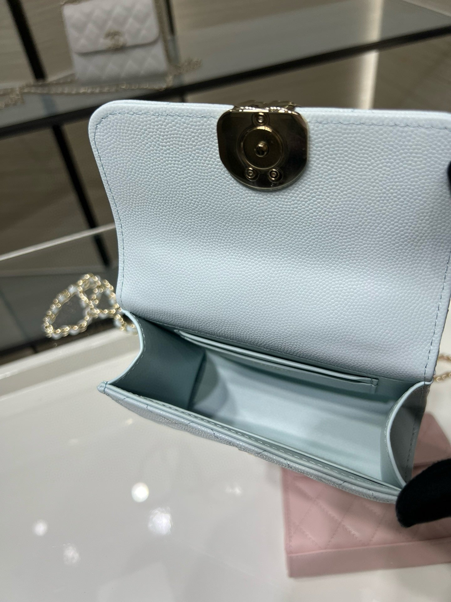 Light blue leather wallet with gold-tone round clasp at center