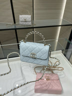 Light blue quilted flap crossbody bag with gold-tone emblem and chain strap