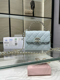 Light blue quilted flap crossbody bag with gold-tone chain strap and emblem clasp
