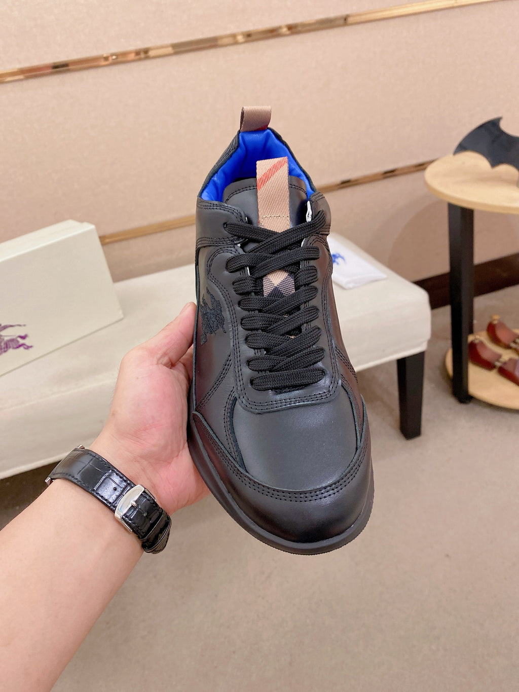Black lace-up sneaker with blue inner lining and plaid-style tongue patch