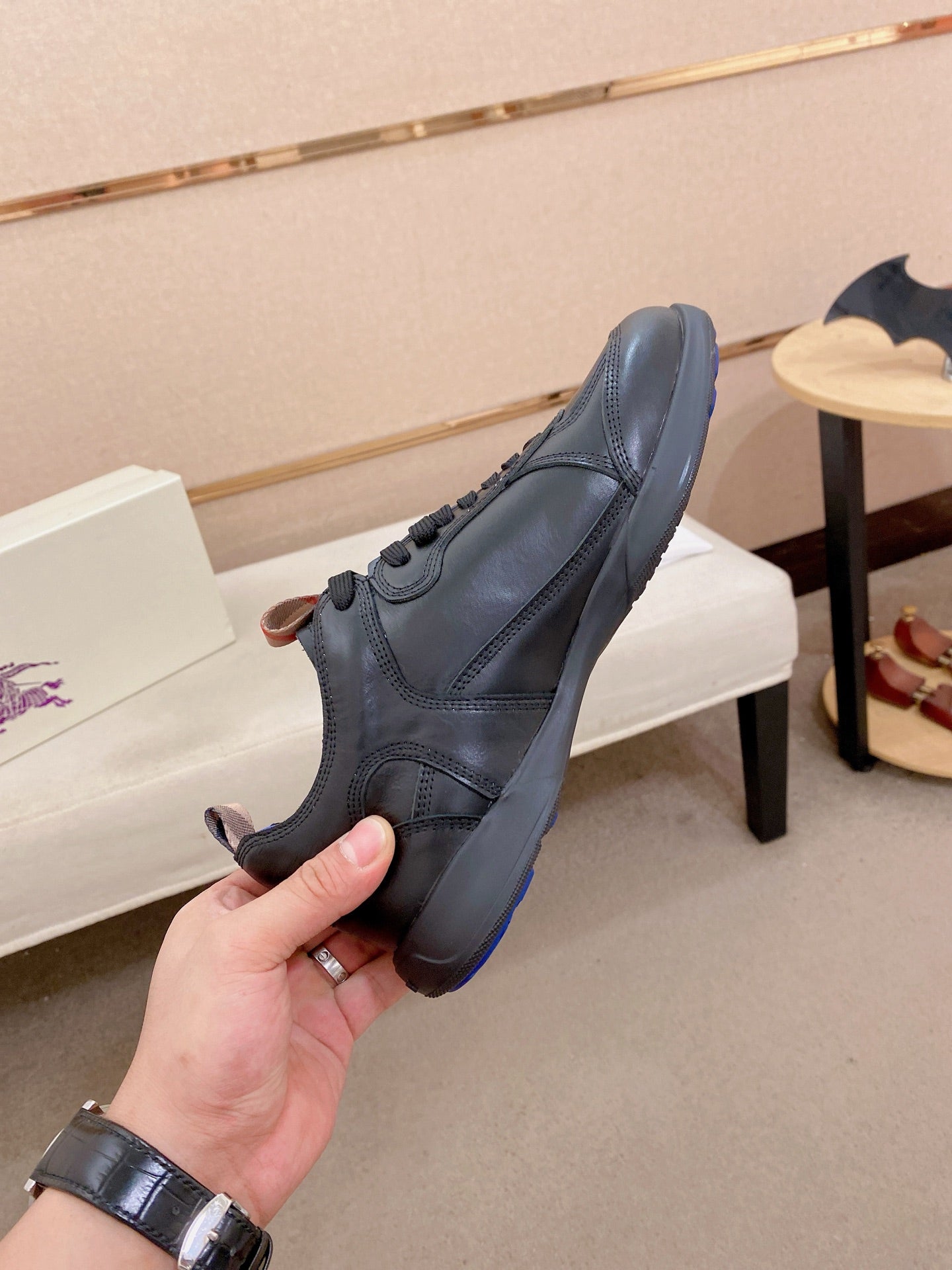 Black lace-up sneaker with blue outsole trim and stitched side panel