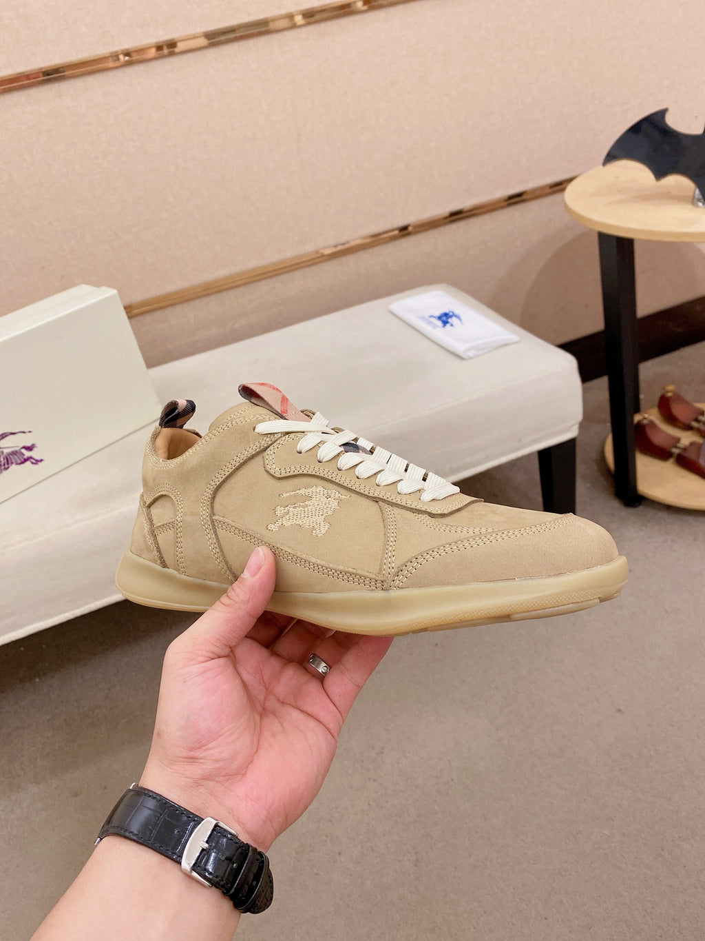 Beige lace-up sneaker with white laces, stitched panels, and low-profile sole