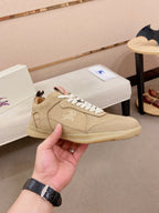 Beige lace-up sneaker with white laces, stitched panels, and low-profile sole