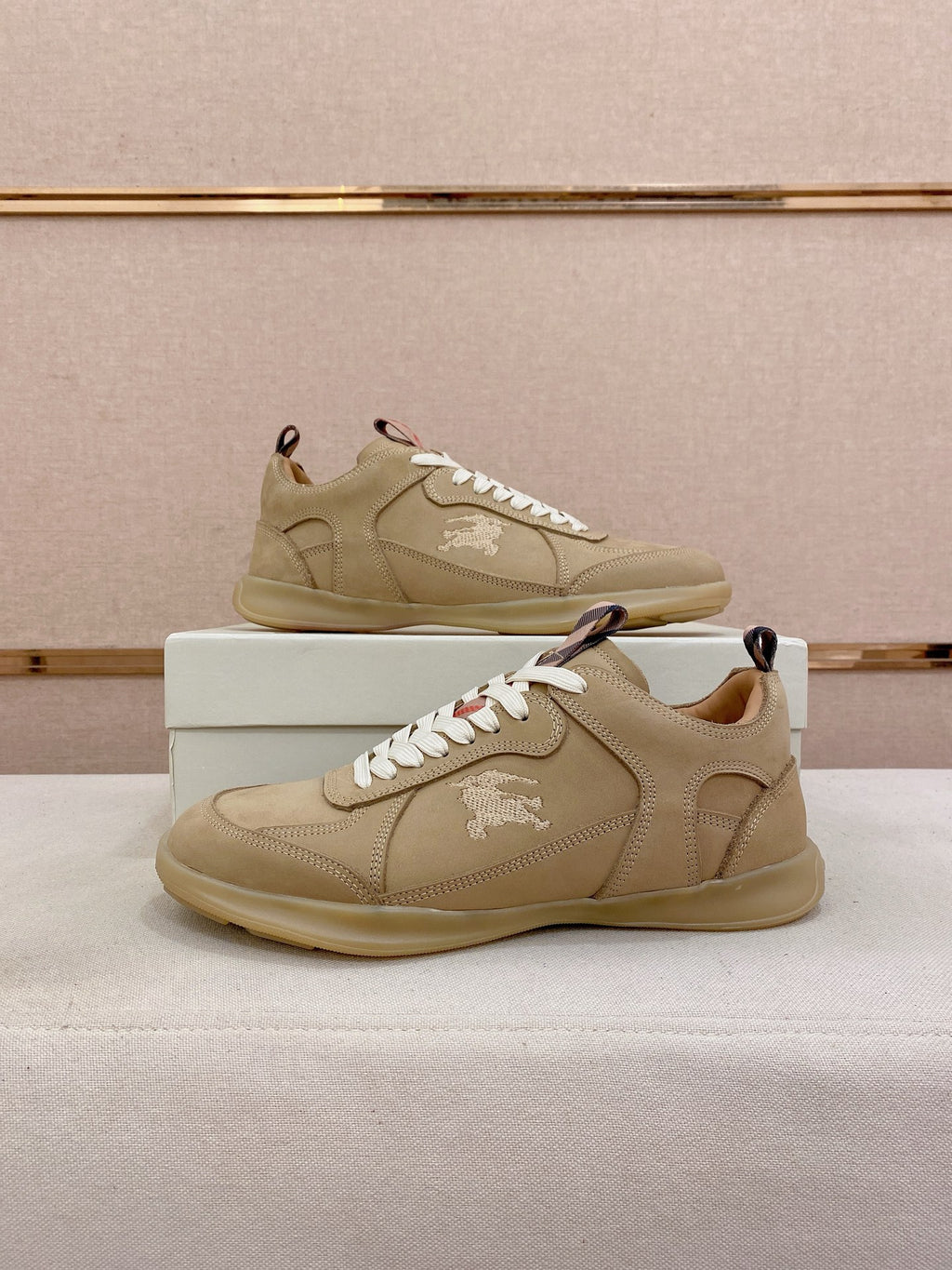 Pair of beige lace-up sneakers with white laces, stitched uppers, and rubber soles