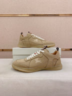Pair of beige lace-up sneakers with white laces, stitched uppers, and rubber soles