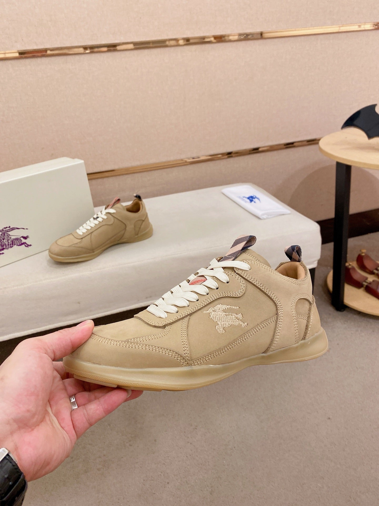 Beige lace-up sneaker with white laces and small logo detail on the side