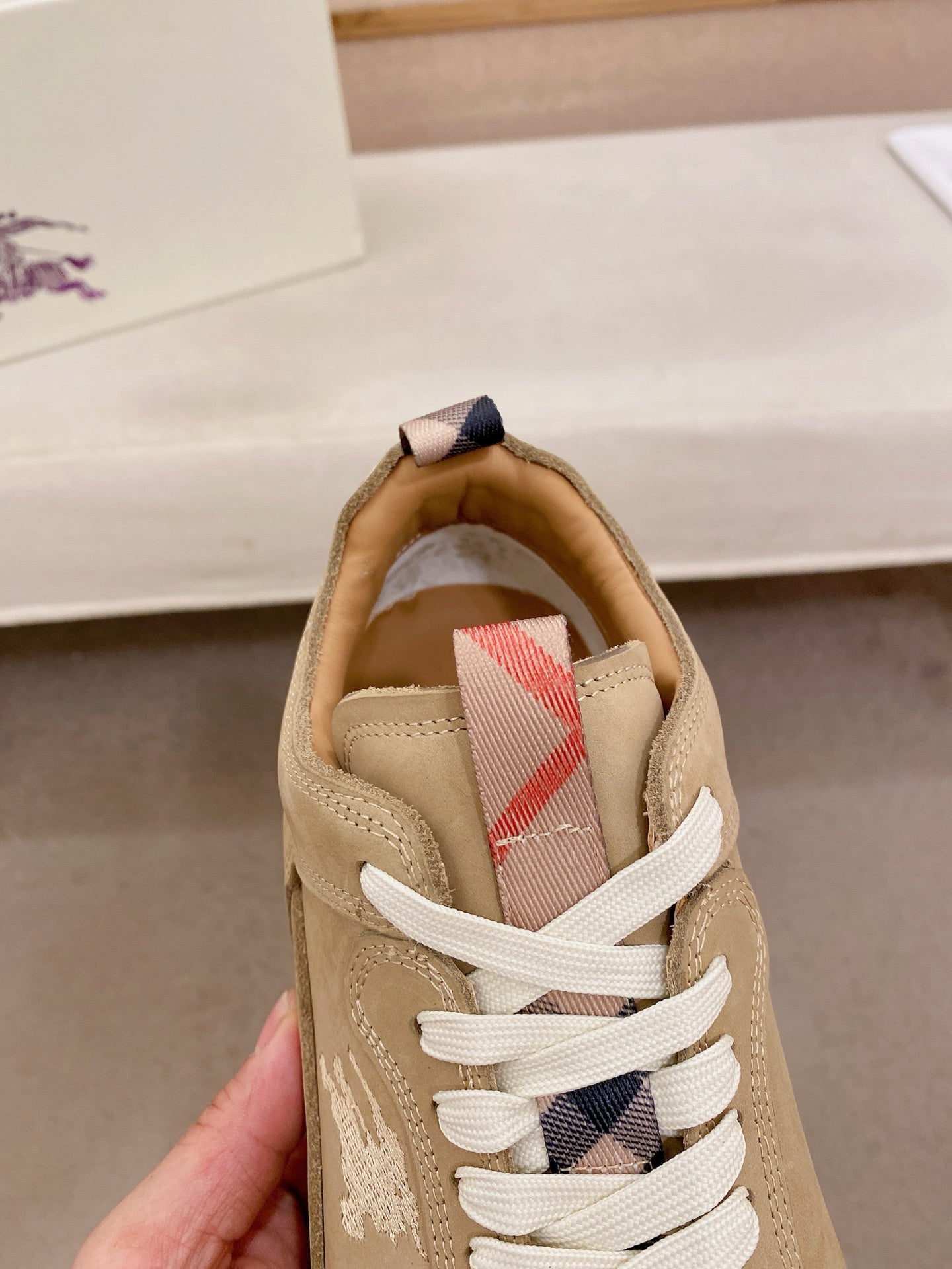 Beige sneaker tongue and lace-up front with plaid-like lining detail