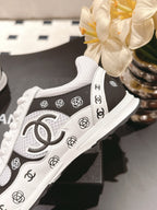 White sneaker with black side panel and large Chanel CC logo, close-up view