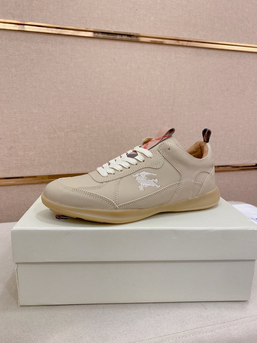 Cream low-top sneakers with lace-up front and stitched logo detail