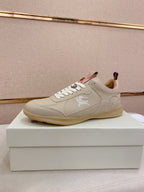 Cream low-top sneakers with lace-up front and stitched logo detail