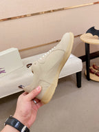 Cream sneaker with lace-up front, gum sole edge, and side profile detail