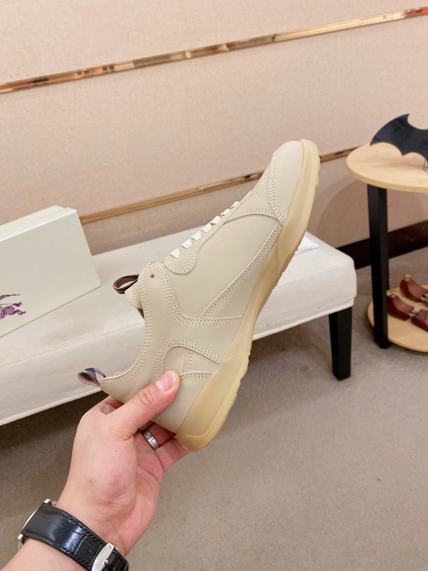Cream sneaker with lace-up front, gum sole edge, and side profile detail