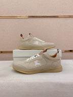 Pair of cream lace-up sneakers on box with embroidered logo on side
