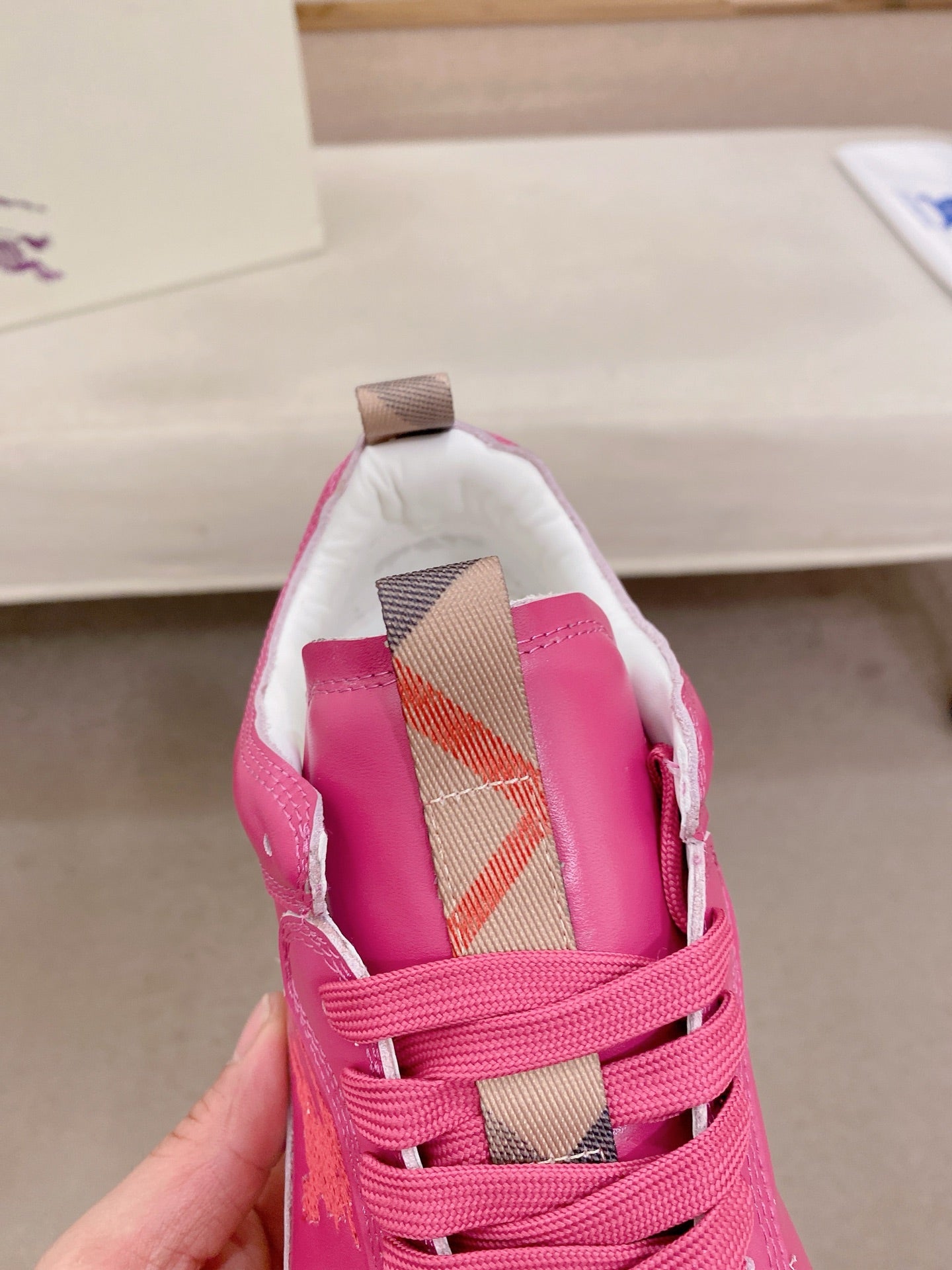 Burberry pink sneakers, close-up of tongue with check-pattern strap detail