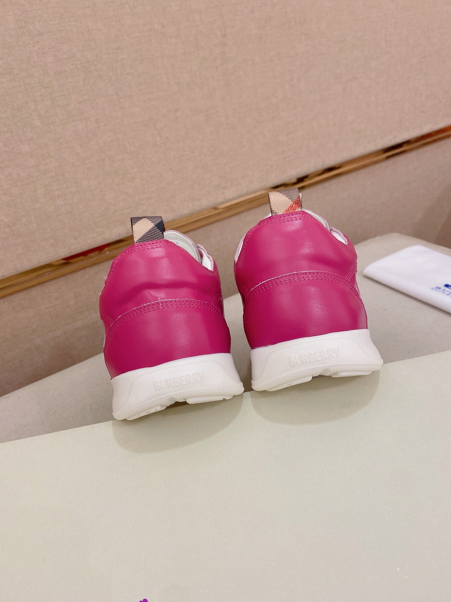 Burberry pink sneakers, back view of heels with lace-up and white sole