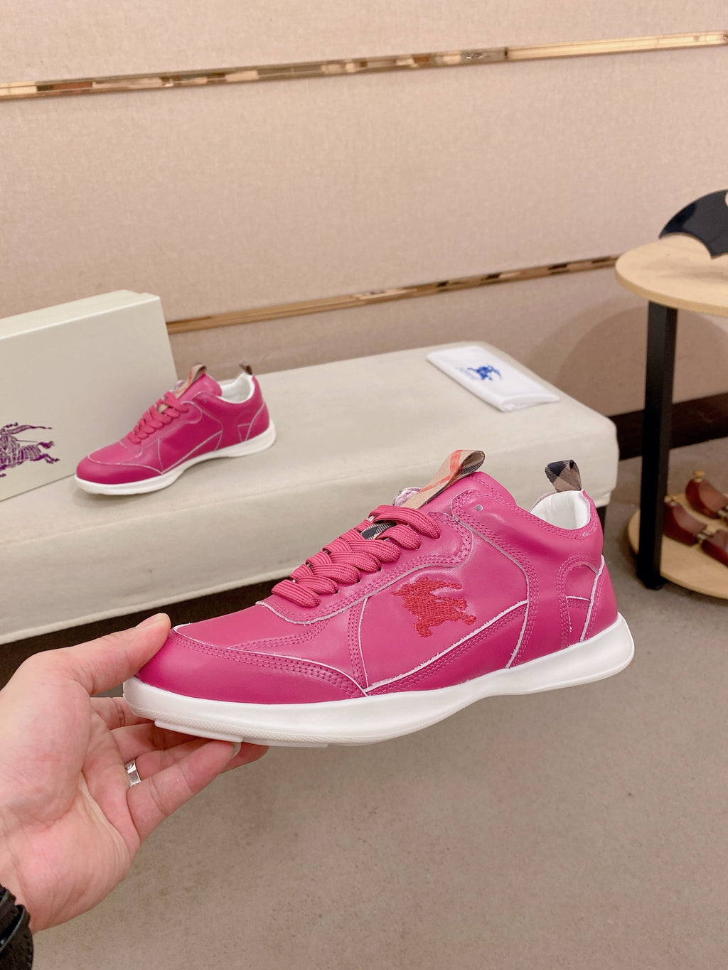 Burberry pink low-top sneakers, hand-held side view with logo detail