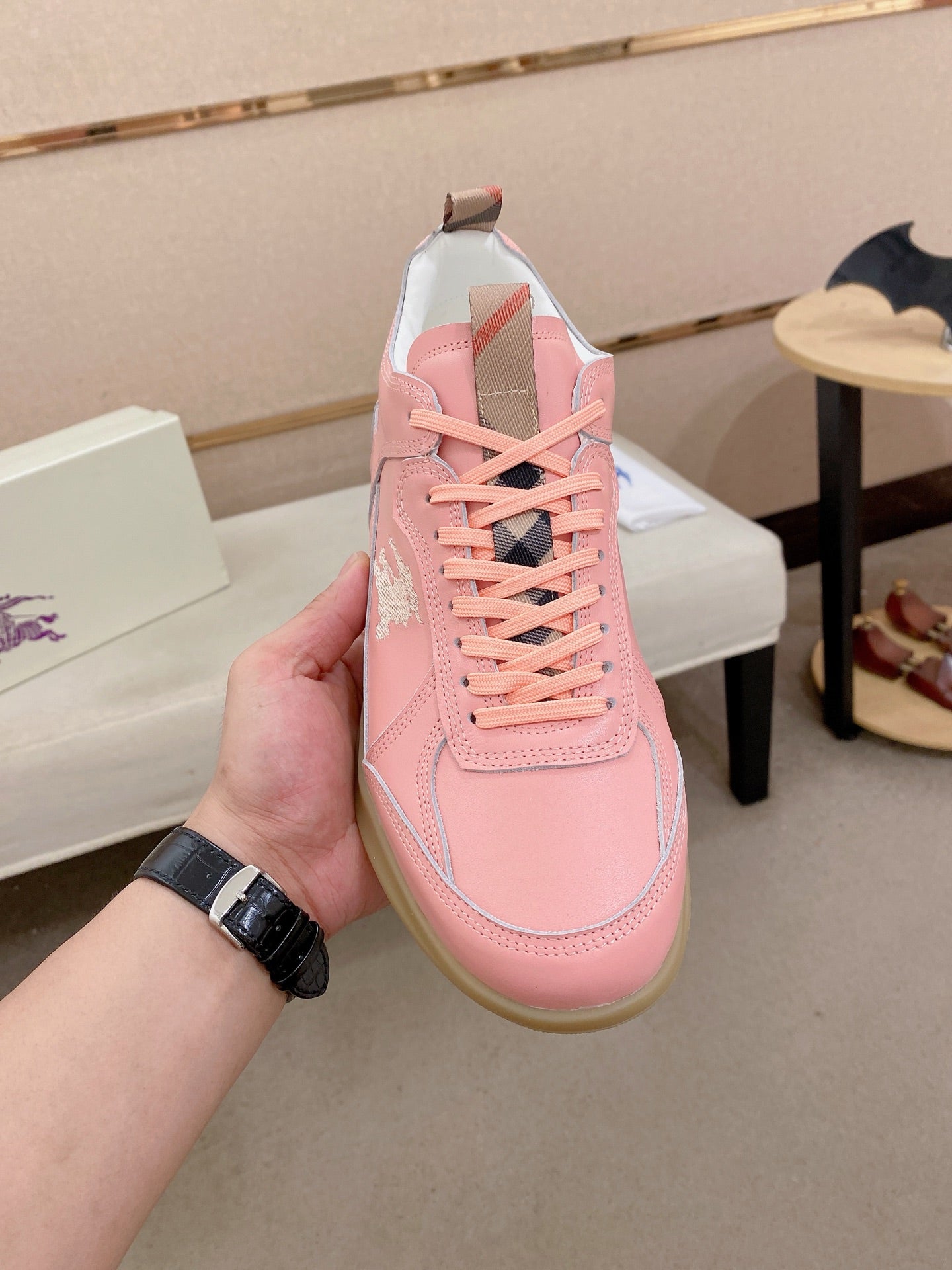 Burberry pink sneaker showing lace-up rows, side panels, and gum sole